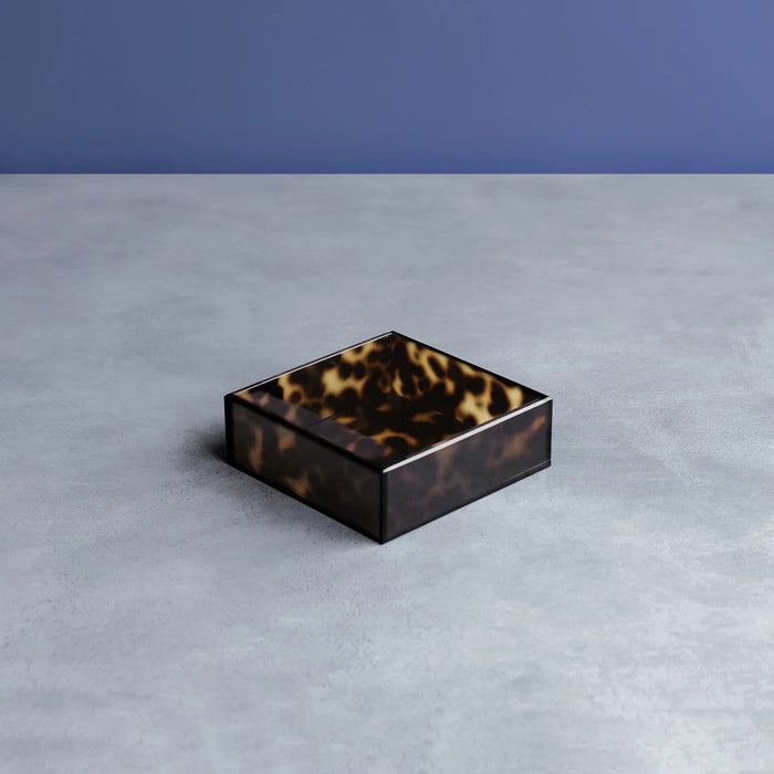 Beatriz Ball Vida Acrylic Tortoise Beverage Napkin Holder — Empty holder on a gray surface