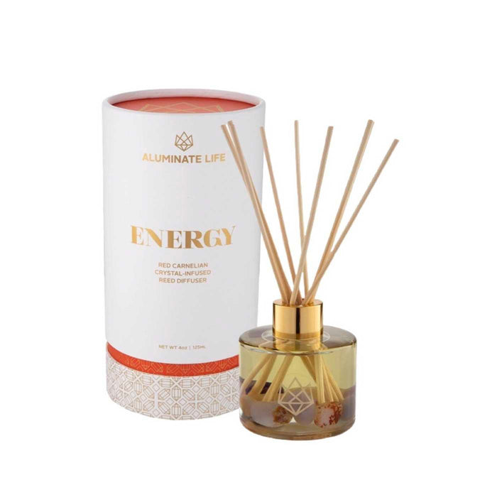 Energy Reed Diffuser | Aluminate Life featuring a glass container with gold accents and reed sticks, alongside a white and orange decorative packaging for a wellness and body care ambiance.