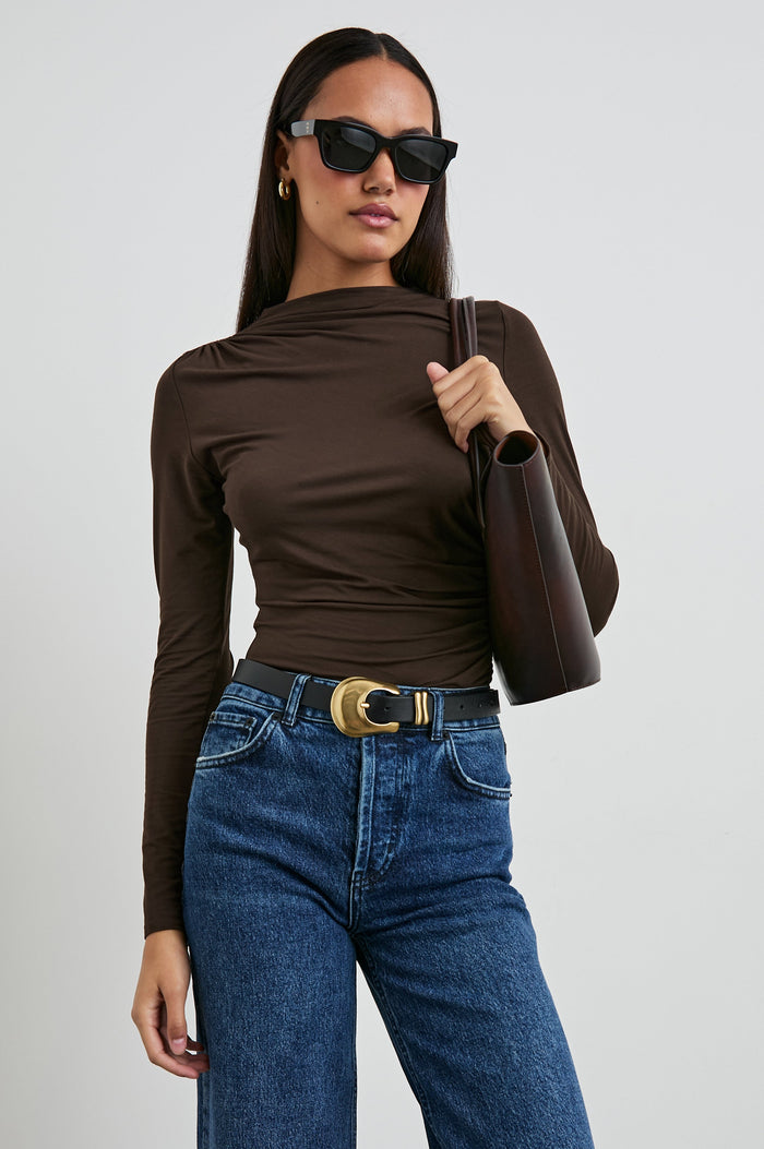 Joelle Long Sleeve Top with An Asymmetrical Mock Neck and Shirring on the Right Shoulder in Espresso Colorway - Front Tucked View Featured on Model