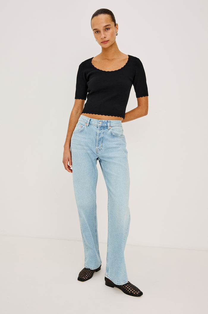 Louanna Fitted Cropped Top in Compact Knit With Scallop-Trimmed Scoop Neckline, Short Sleeves, and Hem in Black Colorway - Full Body Front View Featured on Model
