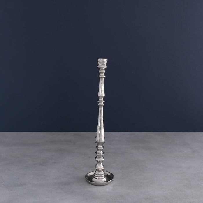 Beatriz Ball Soho Crosby Medium Candlestick Holder — Standing on a gray surface against a dark wall