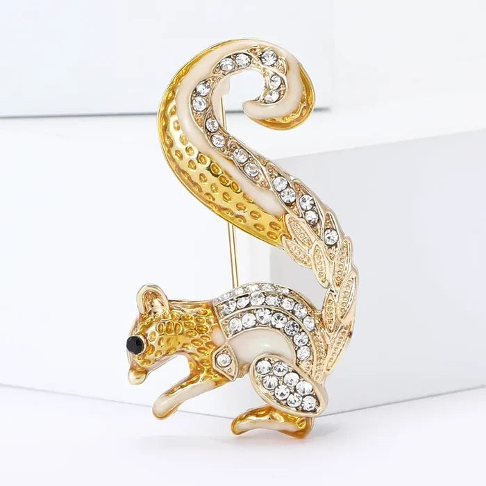 Gold and crystal squirrel brooch on a white background